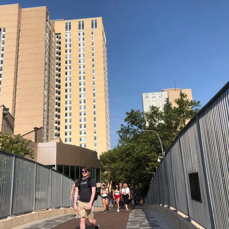 Image of Locust Walk foot bridge in the foreground with the high rise college houses in the background.